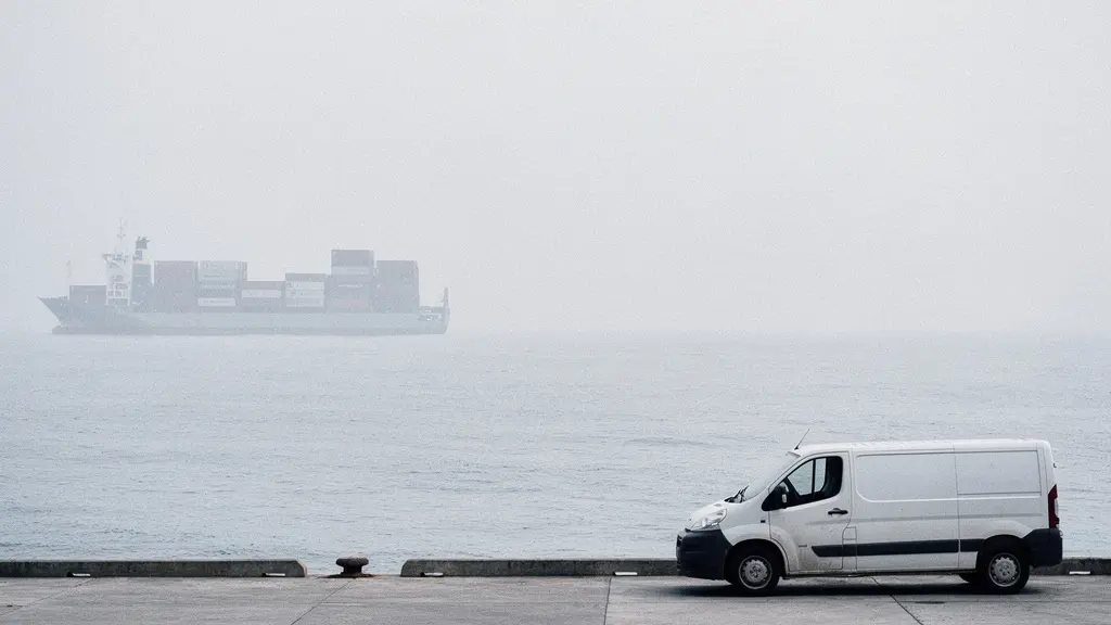 Vue large et minimaliste d'un quai logistique avec une silhouette de porte-conteneurs au loin et un petit véhicule de livraison au premier plan, pour illustrer l'impact du transport.