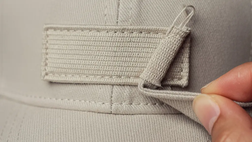 Gros plan sur la texture d’une broderie sur une casquette neutre et un échantillon tissu, illustrant la validation qualité avant production, sans texte.